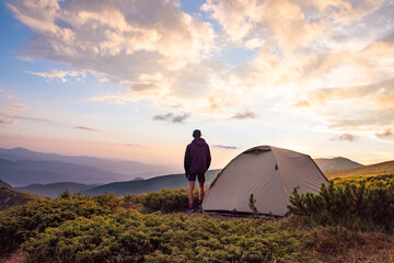 tourist tent and sportsman in mountains, summertime