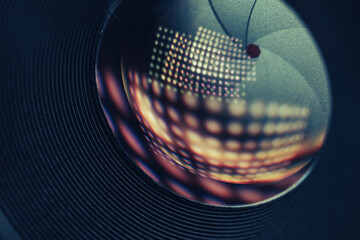 Poster - Beautiful Camera Lens on a dark with yellow shine reflection light background. Macro view.