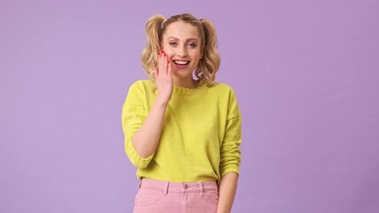 Poster - A charming blond girl shyly laughs at a funny joke in an isolated studio on a purple background