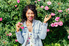 Close-up Portrait Of Enchanting Beautiful Sensual Black Girl With Shiny Eyes Posing With Flower. Spectacular African Woman With Hat Holding Pink Rose And Smiling.