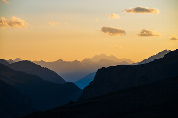 Wall Mural - colorful dawn landscape with beautiful blue mountains silhouettes and golden gradient sky with cloud