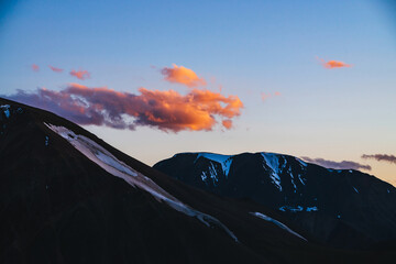 Wall Mural - atmospheric dawn landscape with silhouettes of snowy mountains with glaciers under sunset sky with v