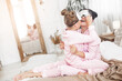 © olenachukhil - Young active mother and her little daughter having fun together at home in the bedroom wearing pajamas