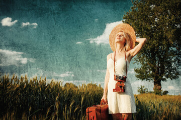 Sticker - Blonde woman with suitcase and camera in wheat field in summer time