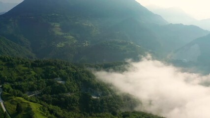 Wall Mural - Bukovo, Slovenia - 4K Flying over the Slovenian alps on a sunny summer morning with fog in the valley 