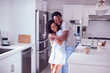© Monkey Business - Loving Couple Wearing Pyjamas Hugging In Kitchen At Home Together