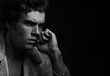 © Anastasia.photoyoga - Handsome serious thinking male model posing in fashion blue jeans jacket looking on dark shadow background. Closeup style portrait. Black and white