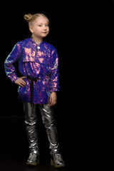 Wall Mural - Cute little girl in a pantsuit. Isolated on a black background.