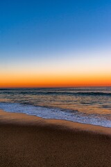 Wall Mural - Beautiful shot of the tide rolling in on a beach at sunset-perfect for mobile wallpaper