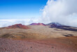 View of Volcano craters from Mauna Kea Mountain summit  on Big Island in Hawaii with breathtaking landscape scenic view from top with clouds and blue sky