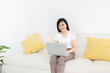 © jokekung - attractive asian female connect internet and social network with laptop, she feeling happy and smile in relax time, work from home
