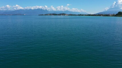 Canvas Print - Slow Flight Over Blue Water.  Flying low over the water in Sirmione Lake Garda Italy. Aerial view