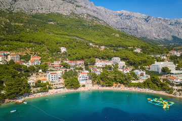 Wall Mural - Amazing aerial view of Makarska riviera, Dalmatia, Croatia. Daytime landscape of popular tourist resort on the Adriatic sea coast at the foot of the rocky Dinara mountains, outdoor travel background