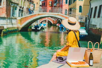 Wall Mural - woman sitting on pier looking at gandolas at venice canal