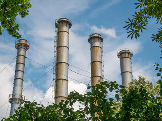 Chimneys of a thermal power plant against blue sky. Power station in Bucharest.