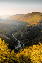 Beautiful idyllic mountain sunset view into the valley with colorful sunligh on a nice autumn outdoor day with fall orange leaves. Harz Mountains, Harz National Park in Germany.