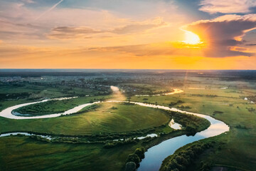 Sticker - Aerial View. Beautiful Sunset Sun Sunshine Above Green Forest, Meadow And River Landscape In Sunny Evening. Top View Of European Nature From High Attitude In Summer Sunrise. Bird's Eye View. Belarus.
