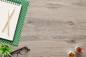 Wall Mural - Wooden home desk with an open sketchbook. Copy space. Green dotted paper.