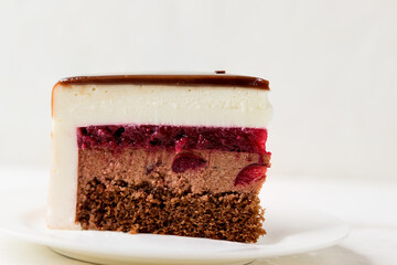 Wall Mural - Delicate cake with chocolate cream, cherry jam on a white background. Piece of cake.