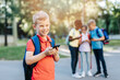 © hedgehog94 - Group of happy elementary school students with smartphones. Primary education, friendship, childhood, and technology concept.