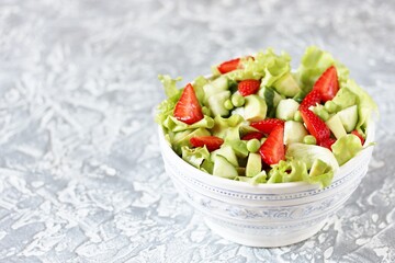 Wall Mural - summer salad with strawberries, avocado, cucumber, green peas. copy space