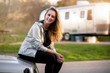 © elnariz - Smiling woman having fun camping outdoors with camper trailer RV, enjoying a fun experience outdoors