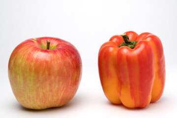 Variegated apple and pepper red and yellow on white background. Concept of Diversity