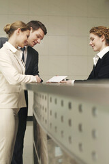 Wall Mural - Receptionist showing letter to businessman and businesswoman