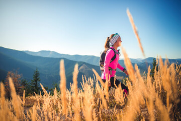 Hiking in summer sunny day in mountains. Hikers walking in nature on top of cliff and enjoying view. Tourist mountain outdoors concept.