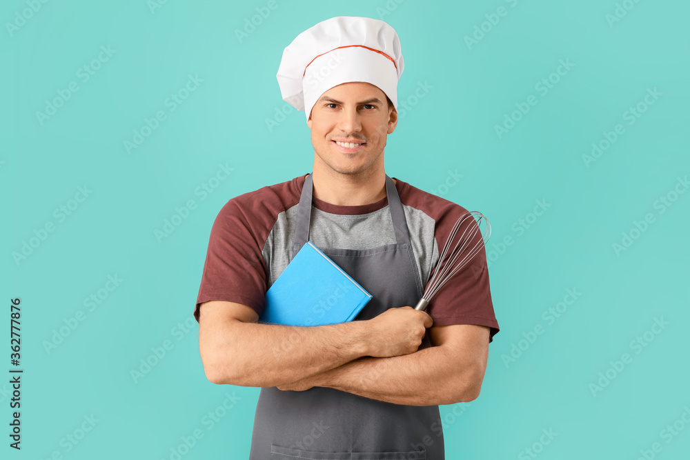 Young man with recipe book on color background