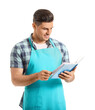 © Pixel-Shot - Young man with recipe book on white background