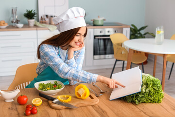 Young woman making tasty salad in kitchen