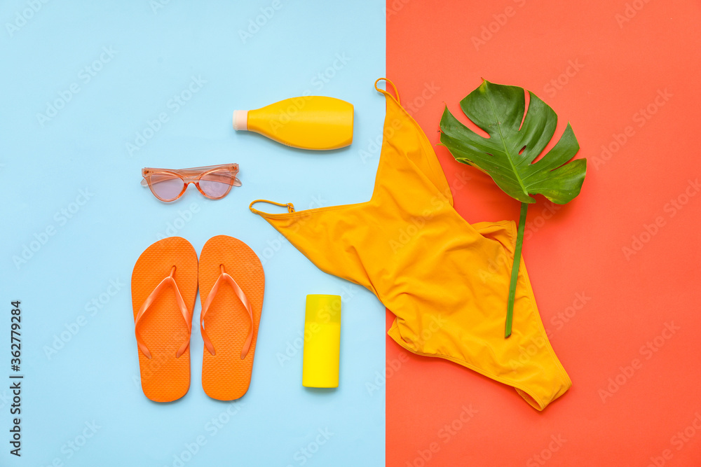 Beach accessories on color background