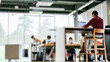 © Bostanika  - A group of people wering mask working or studying online on laptop by social distancing or New normal at library