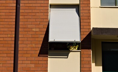 Wall Mural - An isolated open window shutter on a brown vintage house with a brick wall (Pesaro, Italy, Europe)