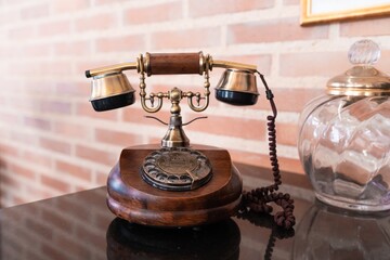 Wall Mural - Closeup of a vintage telephone on the table under the lights with a blurry background