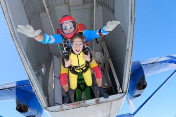 Skydiving. Tandem jump.  Happy girl and her instructor are flying in the sky.