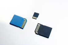 Three Micro SD Memory Cards On Gray Background. Blue And Black Memory Cards For Digital Files, Flat Lay View.