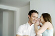 © ImageHit - Woman whispering some sweet words into her boyfriend's ear