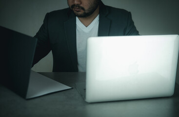 Young businessman doing multitasking work with laptop and document