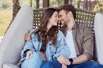 Wall Mural - Smiling young man and woman looking each other outdoors