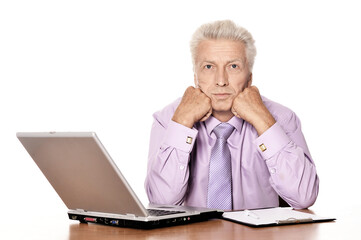 Old businessman working with laptop isolated on white background