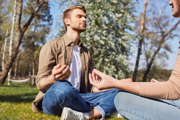 Wall Mural - Relaxed young couple meditating in the garden