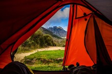 Wonderful Shot Of Outdoors With Mountains Seen From Inside A Red Tent