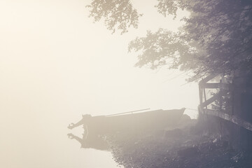 Wall Mural - sea tourism. foggy morning on the lake, bright sun, ship and boat in backlight near the shore.