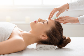 Acupressure head massage for young woman at spa