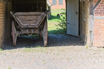 Sticker - Old weathered wagon with wheels near an old wooden gate