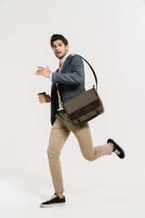 Canvas Print - Photo of young businessman drinking coffee while running with bag