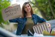 © zinkevych - Pretty young woman holding a garage sale sign