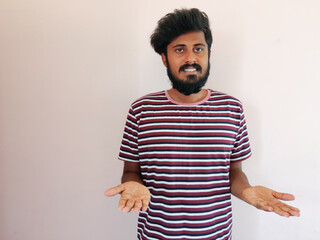 Wall Mural - Indian smiling beard man showing products in his hands. Man is dressed in stripped t-shirt. Isolated on white background.